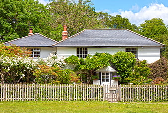 Charming English Cottage With Picket Fence And Lush Green Garden