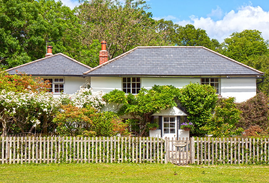 Charming English Cottage With Picket Fence And Lush Green Garden