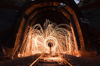 Steel wool sparks light painting in wooden tunnel