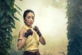 Female Muay Thai Fighter in Traditional Attire and Face Paint