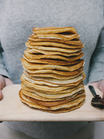 Tall Stack of Golden Pancakes on Wooden Board