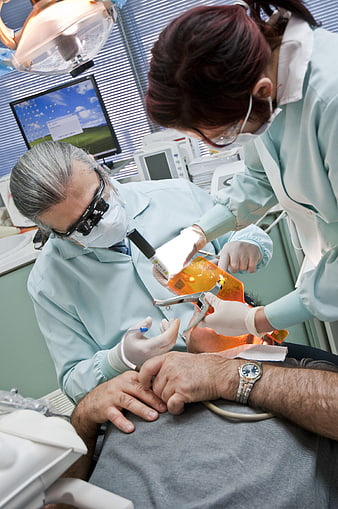 Dentist and assistant performing dental procedure on patient