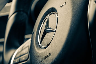 Close-up of Mercedes-Benz steering wheel logo and airbag