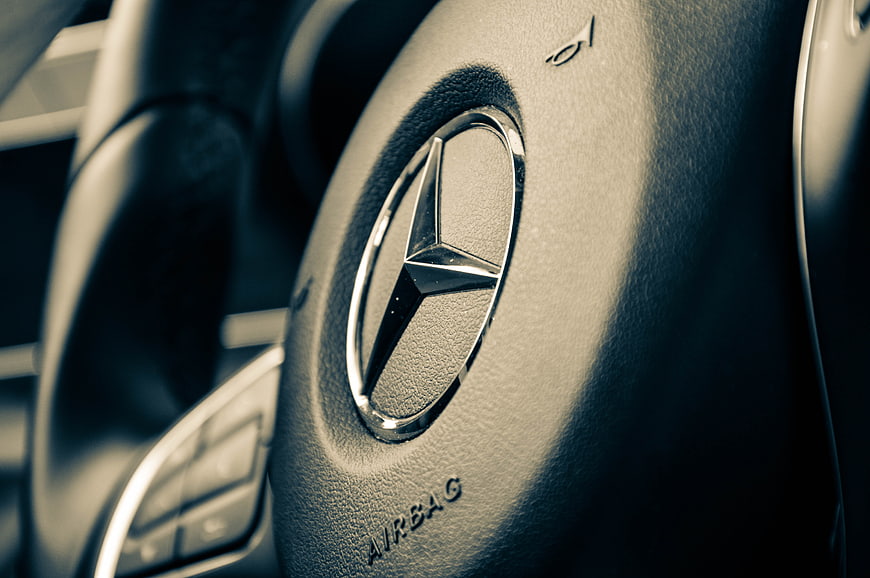 Close-up of Mercedes-Benz steering wheel logo and airbag