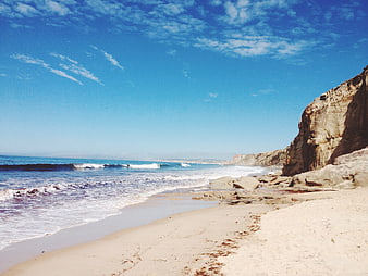 Sunny Beach with Cliffs and Blue Ocean Waves