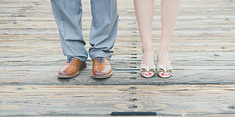 Couple's feet in formal shoes on wooden deck