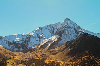 Snow-Capped Mountain Peak with Golden Autumn Slopes