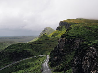 Winding Road Through Green Highland Mountains