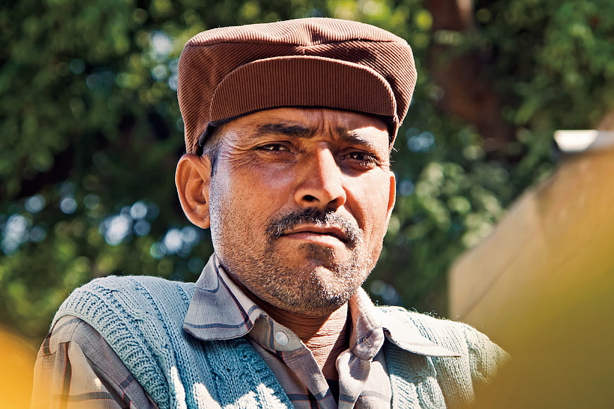 Portrait of Indian Man in Cap and Sweater Vest Outdoors