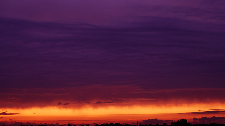 Dramatic purple and orange sunset sky with clouds
