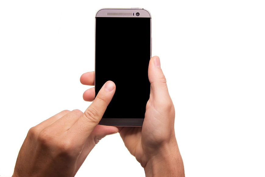 Hands holding smartphone with black screen on white background