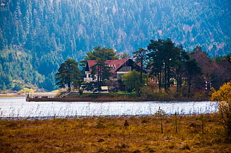 Secluded lakeside house with forested mountain backdrop