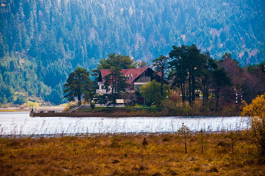 Secluded lakeside house with forested mountain backdrop