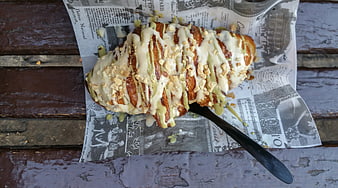 Overhead view of glazed pistachio croissant on newspaper