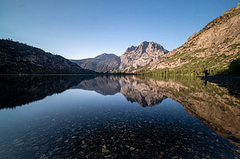 Serene Mountain Lake Reflection with Hiker