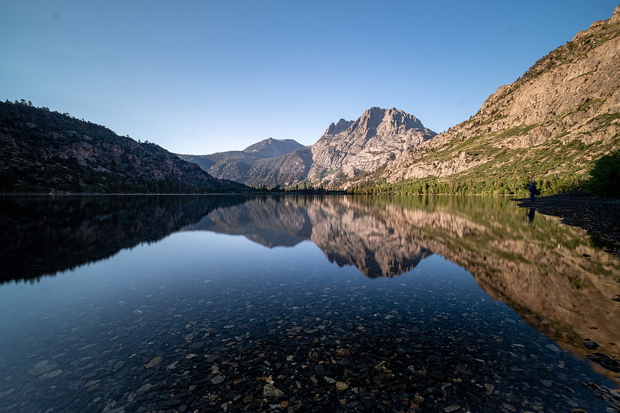 Serene Mountain Lake Reflection with Hiker