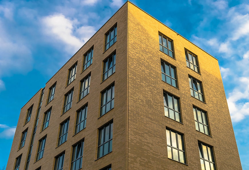 Modern Yellow Brick Building Against Blue Sky