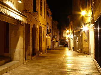 Quiet cobblestone street in Mallorca at night with warm lighting