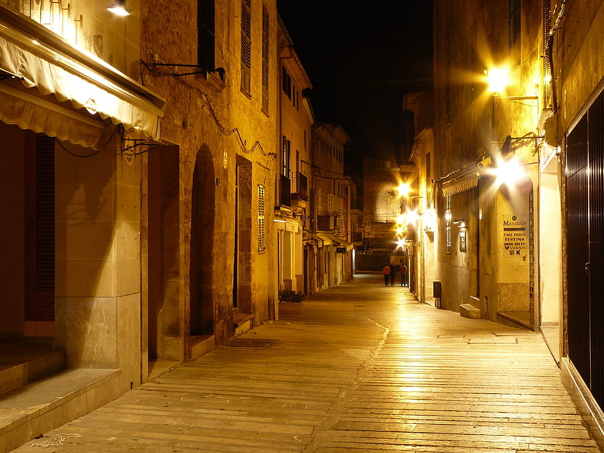 Quiet cobblestone street in Mallorca at night with warm lighting