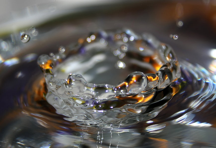 Macro shot of water splash crown with amber reflections