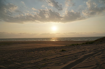 Golden Sunset Over Beach Dunes And Ocean Horizon