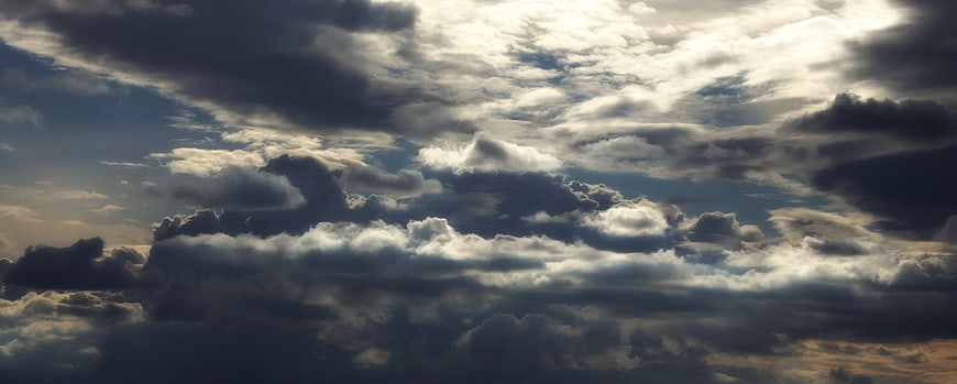 Dramatic dark storm clouds with bright sunlight breaking through
