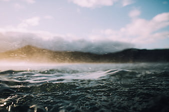 Cinematic Ocean Waves with Blurred Mountain Background