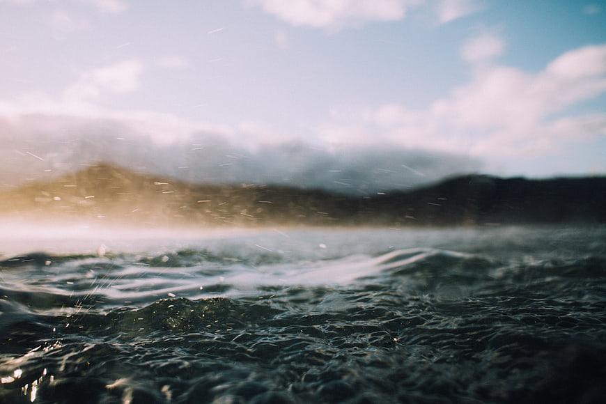 Cinematic Ocean Waves with Blurred Mountain Background