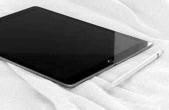 Black Tablet and Stylus on White Bedding