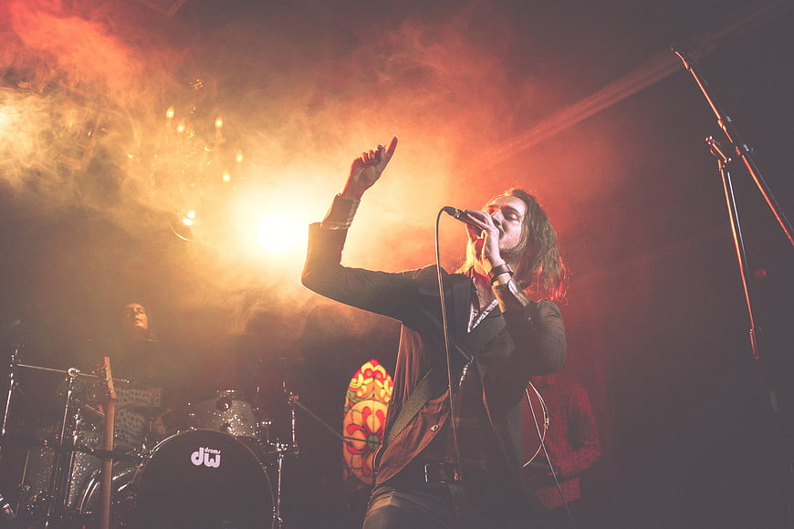 Male Rock Singer Performing on Stage with Dramatic Lighting