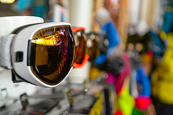 Close-up of white sports sunglasses with amber lenses on display rack