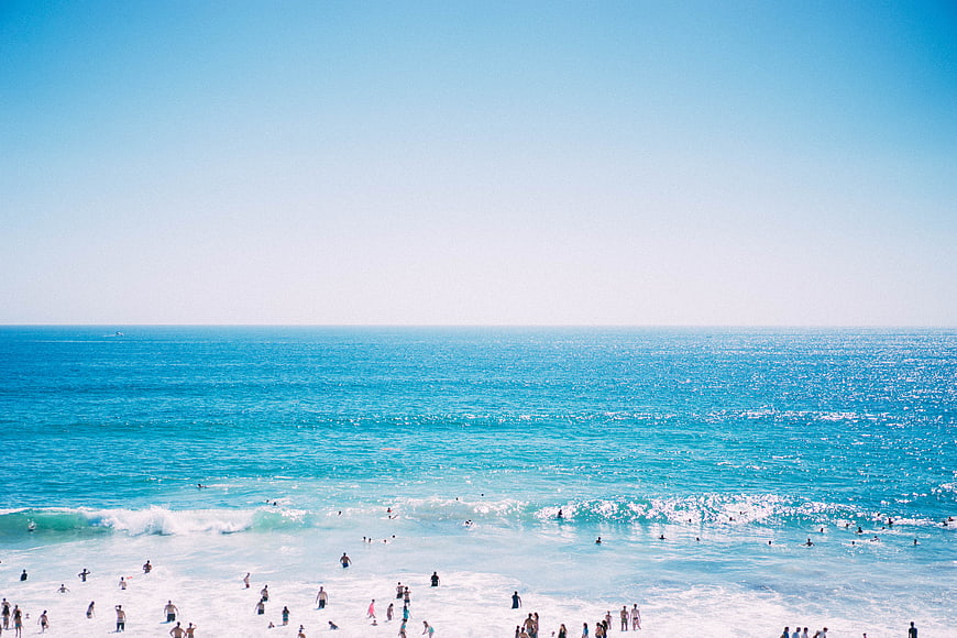 Wide Angle Summer Beach Scene with Turquoise Ocean and Swimmers