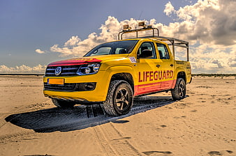 Yellow Volkswagen Lifeguard Pickup Truck on Sandy Beach