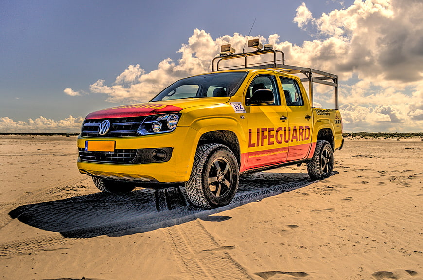 Yellow Volkswagen Lifeguard Pickup Truck on Sandy Beach