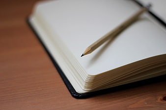 Close-up of wooden pencil on open notebook page