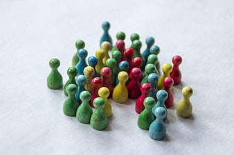 Colorful Wooden Human Figurines Grouped Together on White Surface