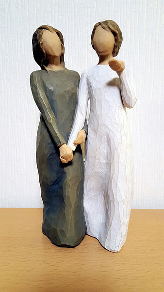 Hand-carved wooden figurines of two women holding hands