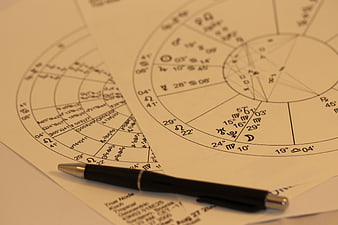 Astrological Birth Charts and Pen on Desk