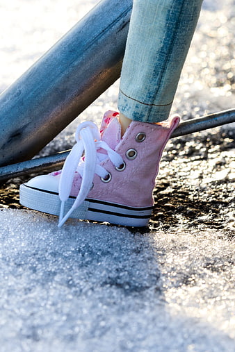 Child's pink sneakers on icy playground equipment