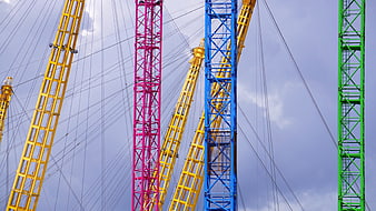 Colorful Construction Cranes Against Cloudy Sky