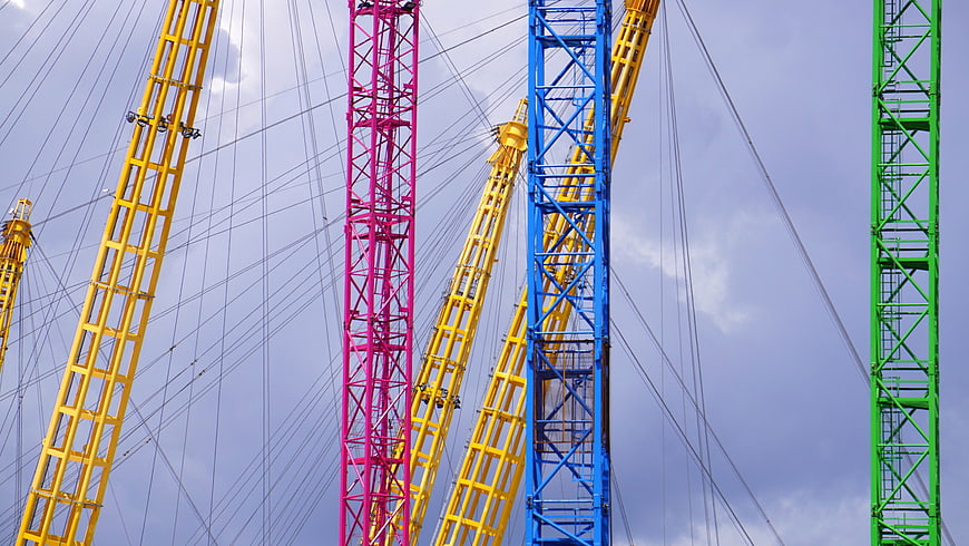 Colorful Construction Cranes Against Cloudy Sky