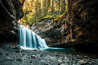 Majestic Waterfall in Rocky Canyon with Forest