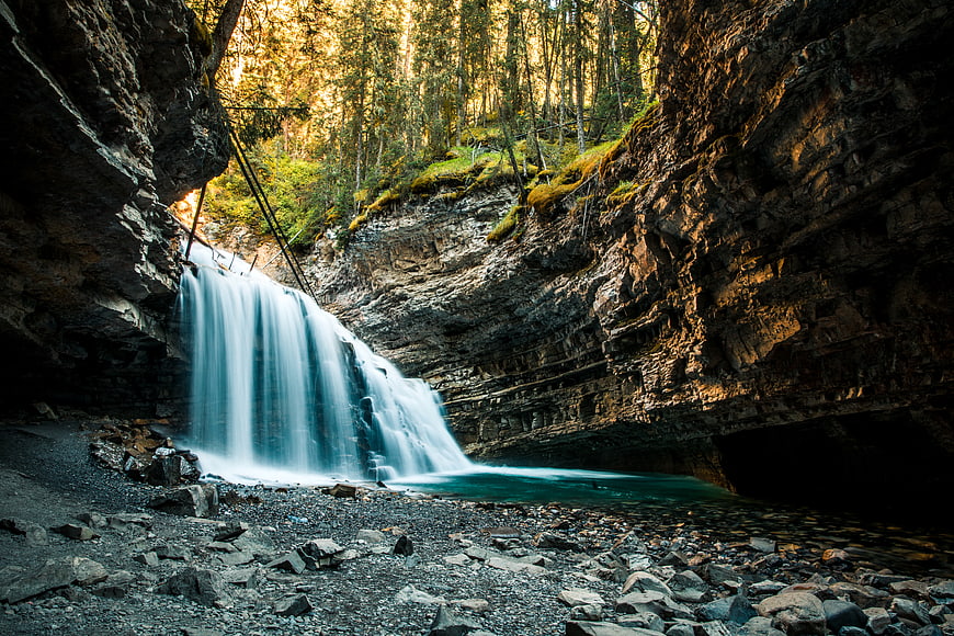 Majestic Waterfall in Rocky Canyon with Forest