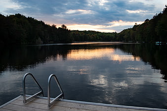 Serene Lake Sunset View from Wooden Dock with Metal Ladder