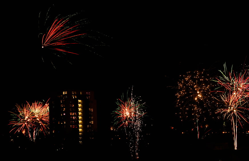 Colorful fireworks exploding over city skyline at night