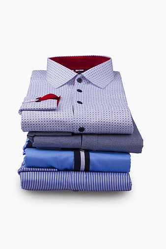 Stack of folded men's dress shirts on white background
