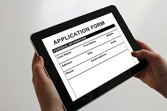 Hands holding tablet with digital application form