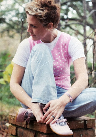 Candid portrait of woman in pink vest sitting outdoors
