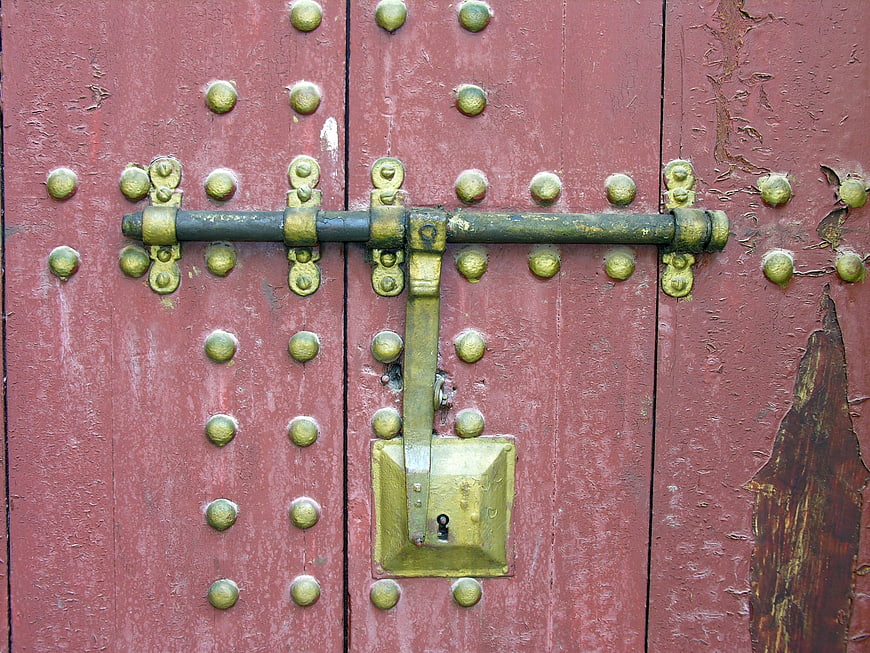 Close-up of vintage red wooden door with brass lock