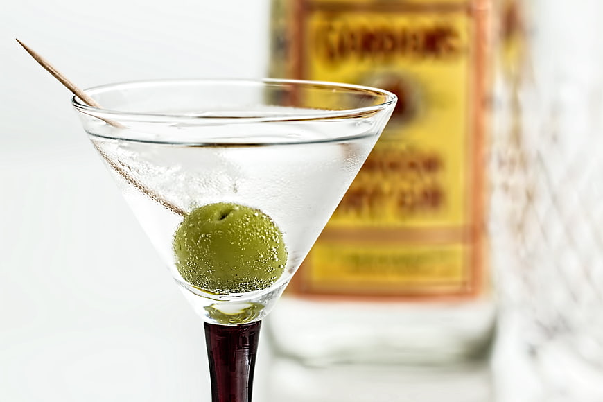 Classic Martini Cocktail With Green Olive Garnish And Gin Bottle